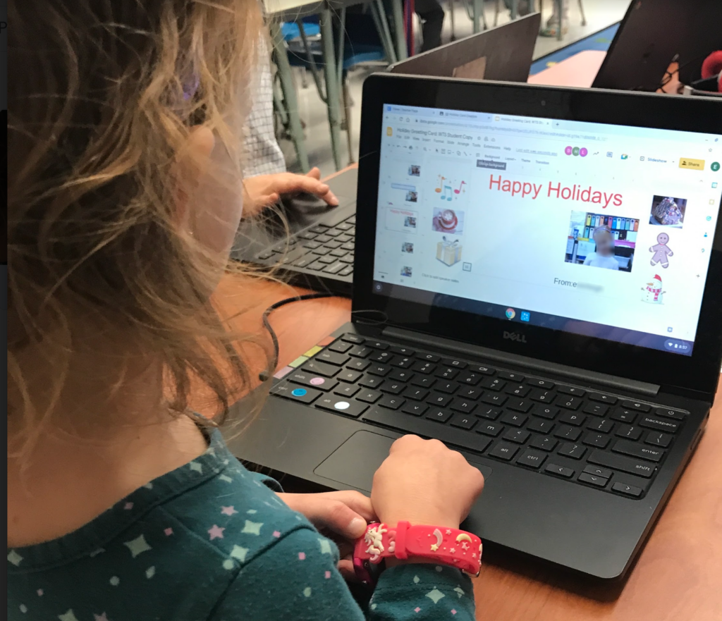 Child working in Google Slides on Holiday Greeting Card Designing activity.